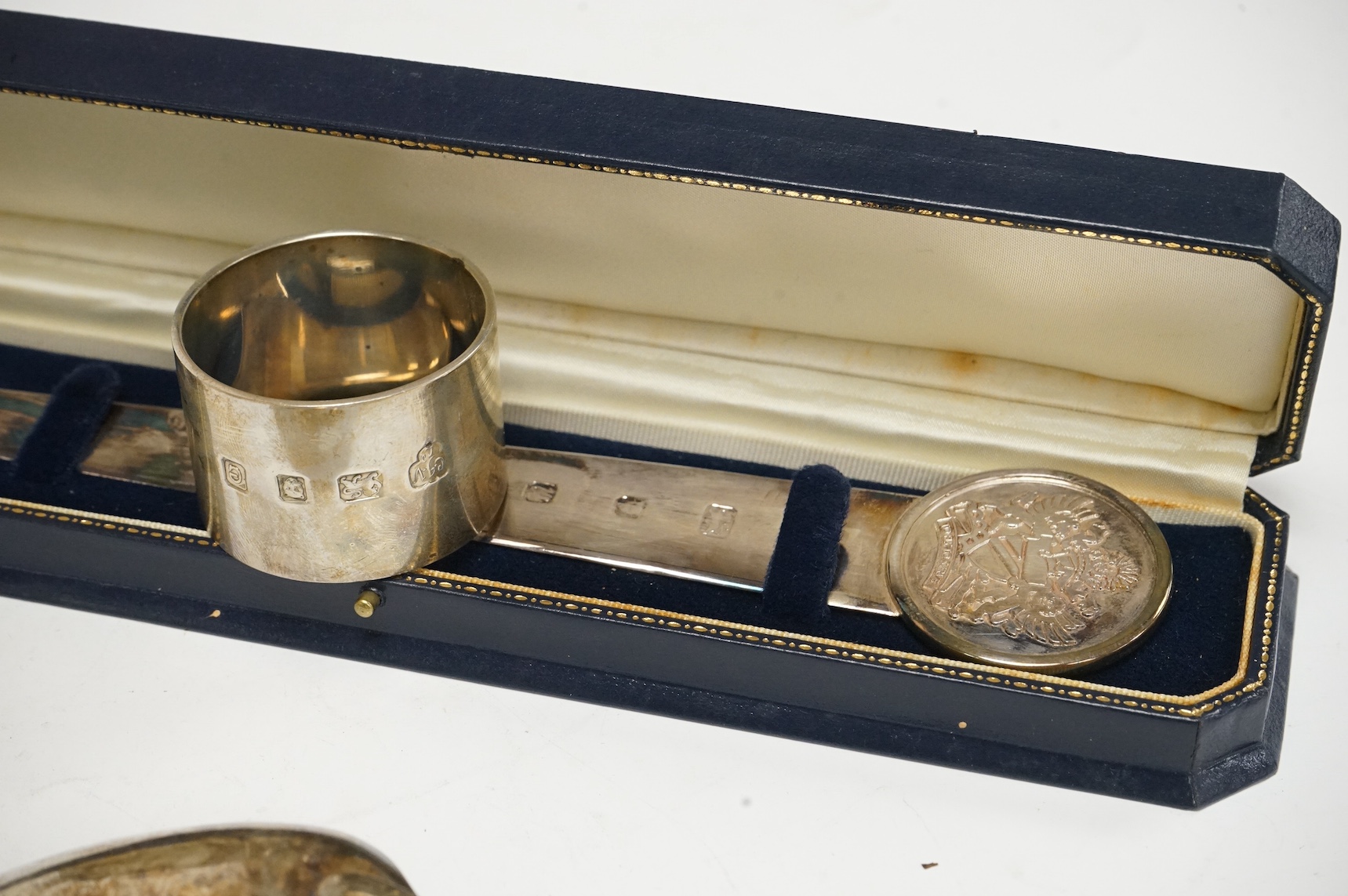 Three assorted George III silver fiddle pattern table spoons, a modern silver spirit label, ‘’Brandy’’, two silver letter openers and a heavy silver serviette ring. Condition - poor to fair to good